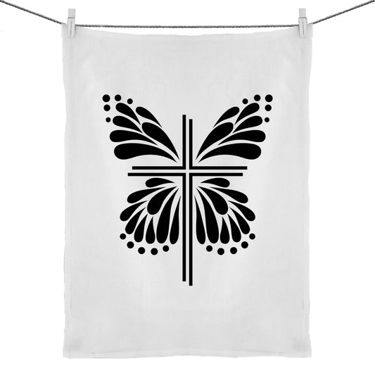 Cross with Butterfly wings around it on a white teatowel. Graphic is in black. Inspiration is from the bible; Therefore, if anyone is in Christ, he is a new creation. The old has passed away; behold, the new has come. 2 Corinthians 5:17