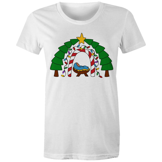 Women's Christian White T-shirt by Christianitee featuring a cosy nativity scene with baby Jesus in a manger, framed by a candy cane and Christmas light arch, evergreen trees, and a star. A festive design celebrating the joy and meaning of Christmas.